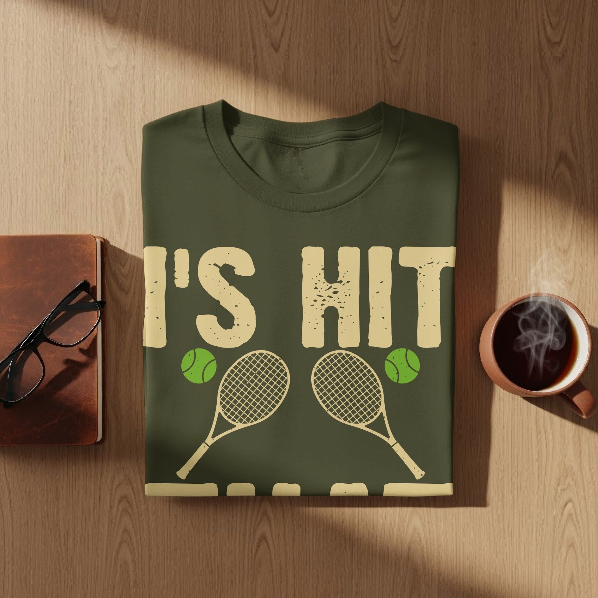 T-shirt with text "I'S HIT" and tennis rackets and balls.