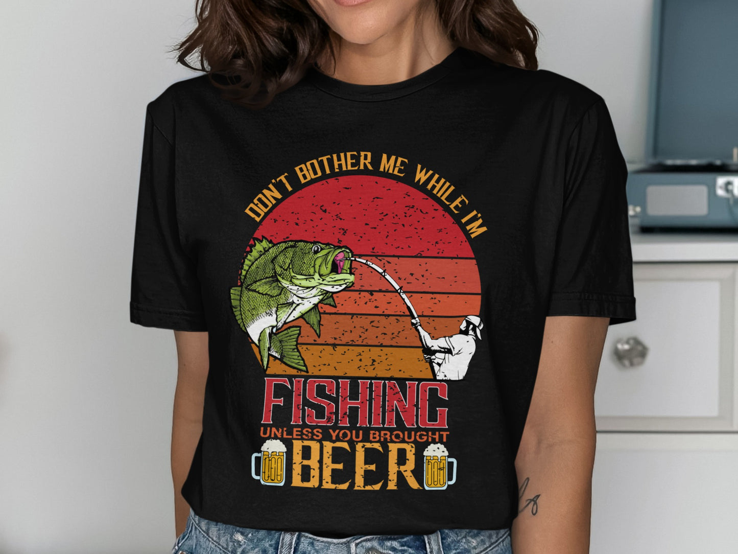 Black t-shirt with fishing graphic and text: "Don't bother me while I'm fishing unless you brought beer."