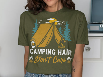 Olive green t-shirt with tent, campfire, trees, and "Camping Hair Don't Care" text.