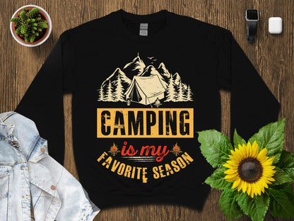 Black sweatshirt with "Camping is my favorite season" text and mountain graphic.