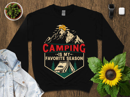 Black sweatshirt with "Camping Is My Favorite Season" text and mountain tent graphic.