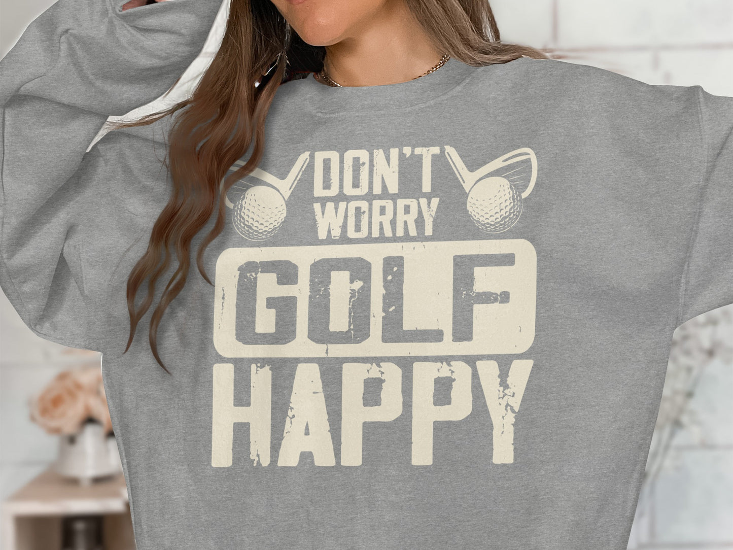Grey sweatshirt with "Don't Worry Golf Happy" text and golf club graphics.