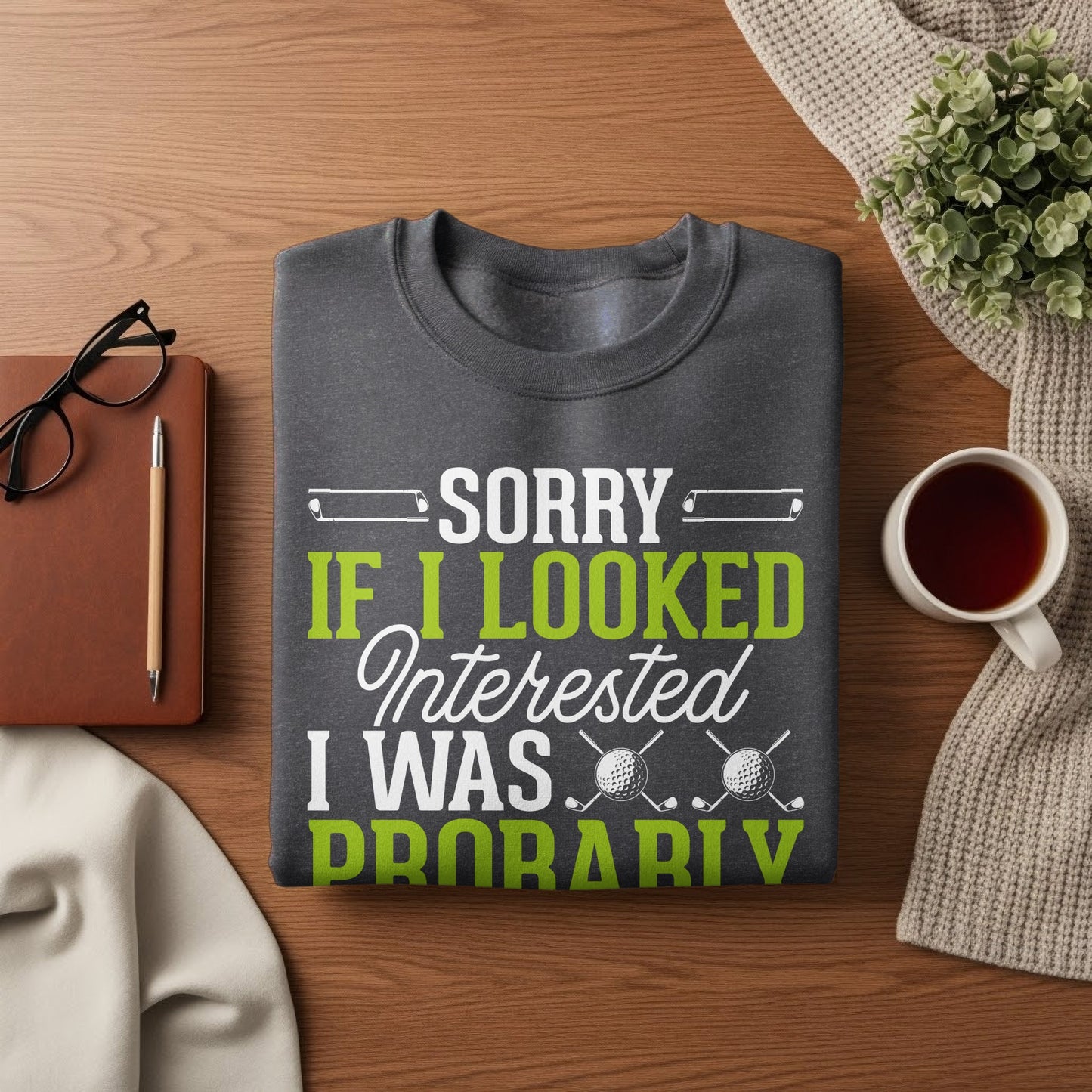 Grey sweatshirt with "Sorry if I looked interested I was probably" text and golf graphic.