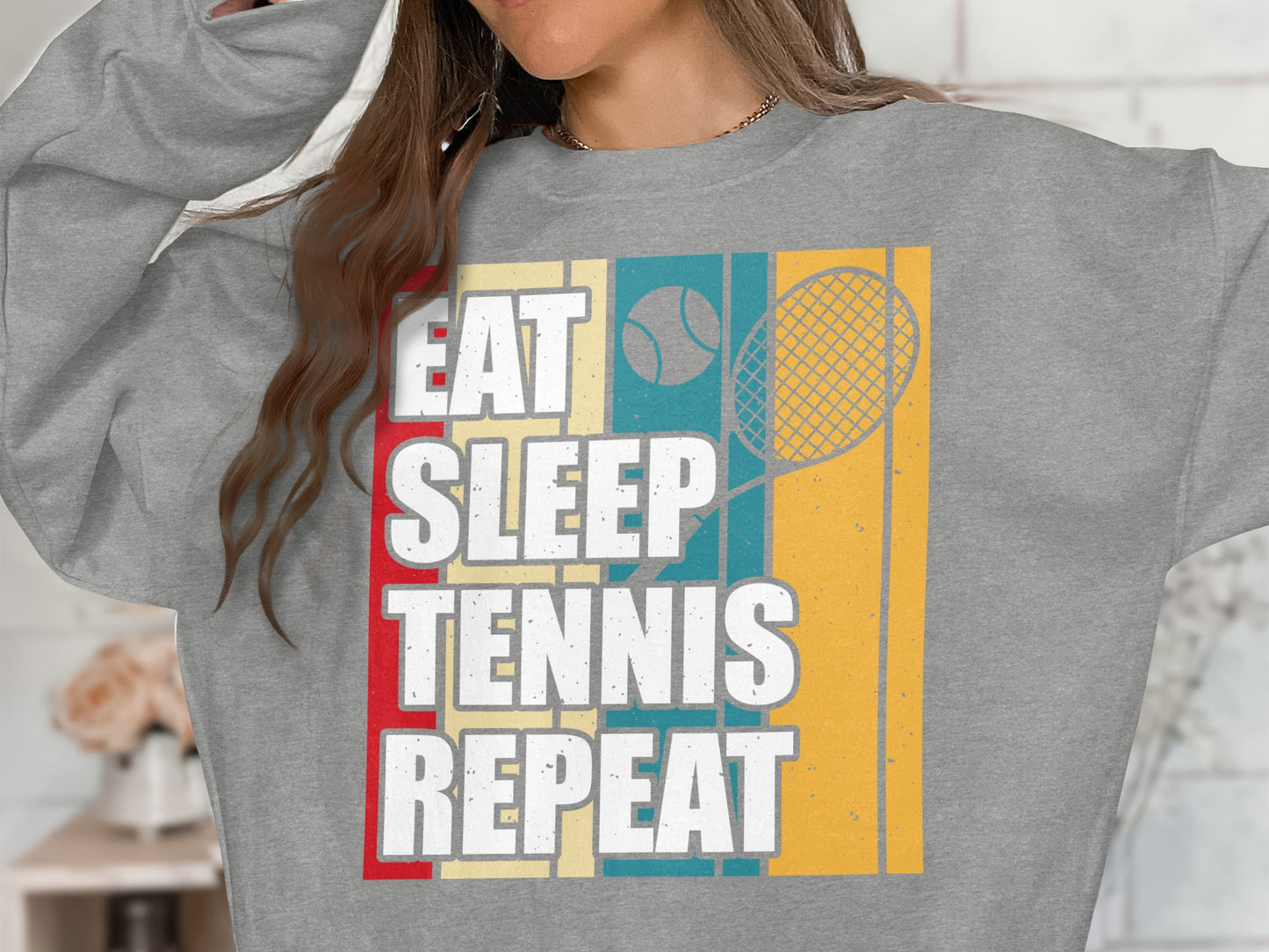 Gray sweatshirt with "Eat Sleep Tennis Repeat" text and tennis racket graphic.