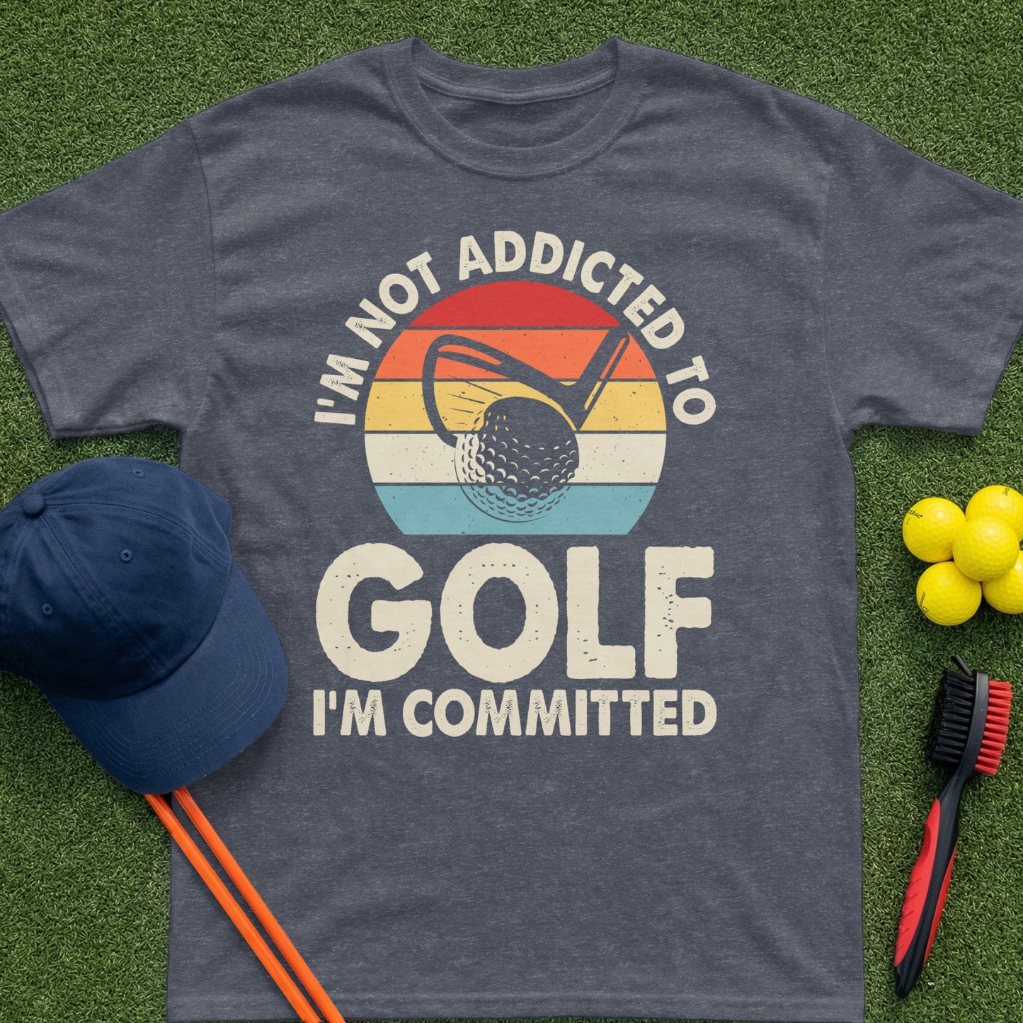 T-shirt with text "I'm not addicted to golf, I'm committed" and golf imagery.