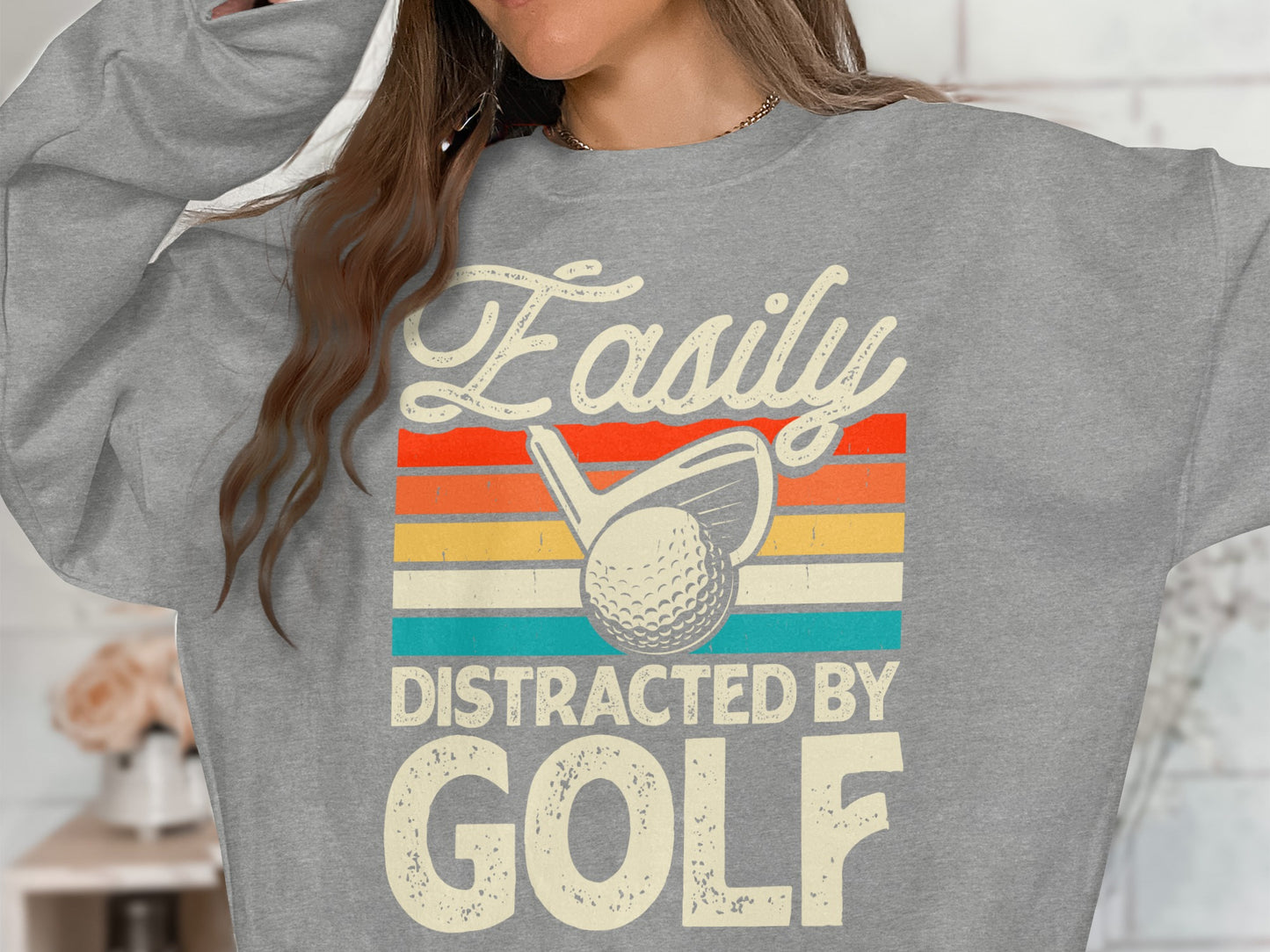 Grey sweatshirt with "Easily Distracted by Golf" text and golf club.