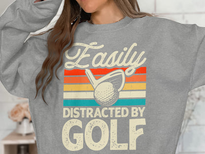 Grey sweatshirt with "Easily Distracted by Golf" text and golf club.
