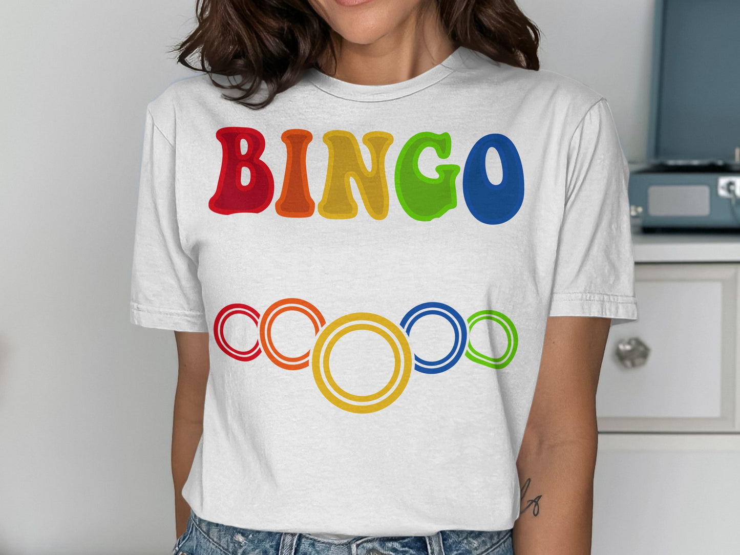 White t-shirt with colorful "BINGO" text and concentric circles below.