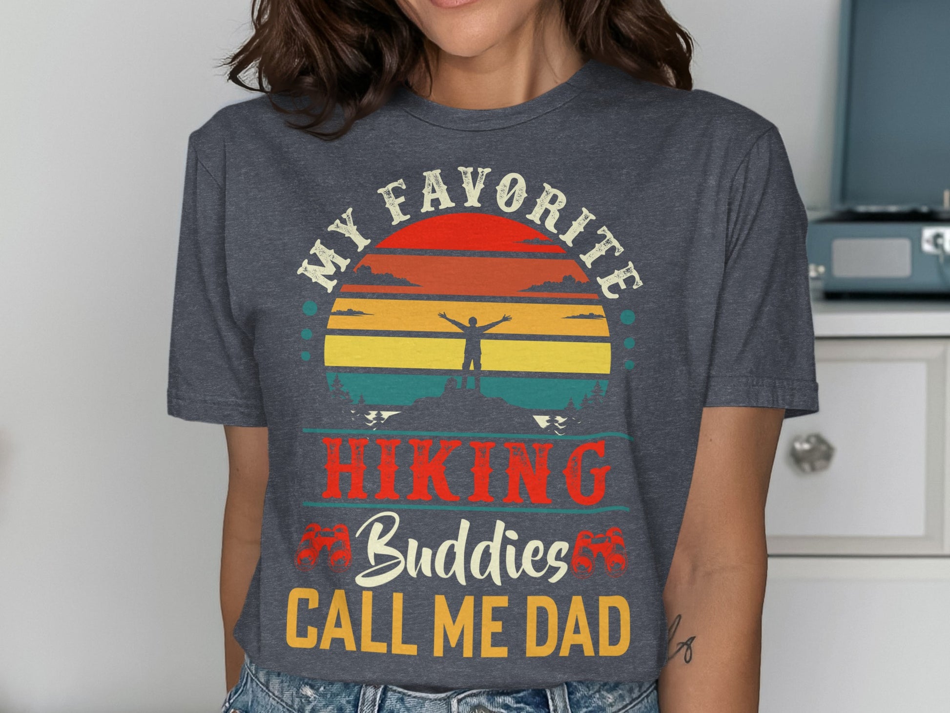 T-shirt with "My Favorite Hiking Buddies Call Me Dad" and sunset graphic.