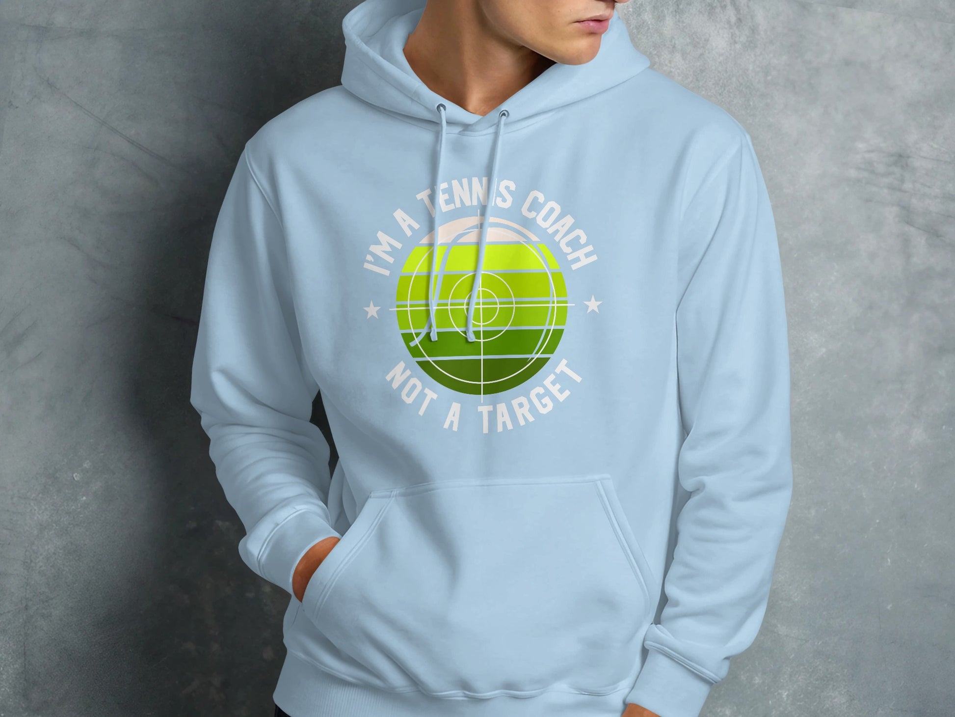 Light blue hoodie with "I'm a tennis coach, not a target" graphic.