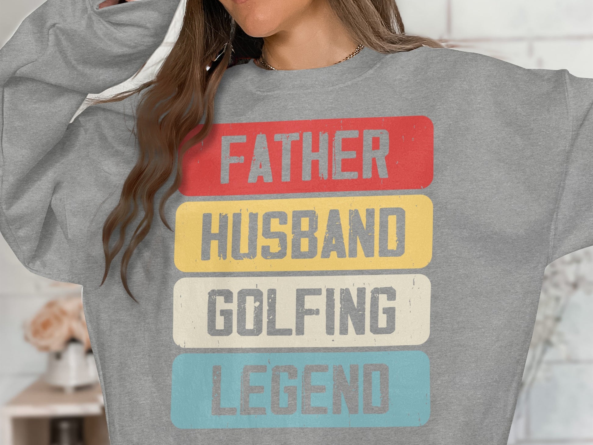 Grey sweatshirt with red, yellow, and blue text: Father, Husband, Golfing, Legend.
