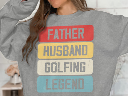 Grey sweatshirt with red, yellow, and blue text: Father, Husband, Golfing, Legend.