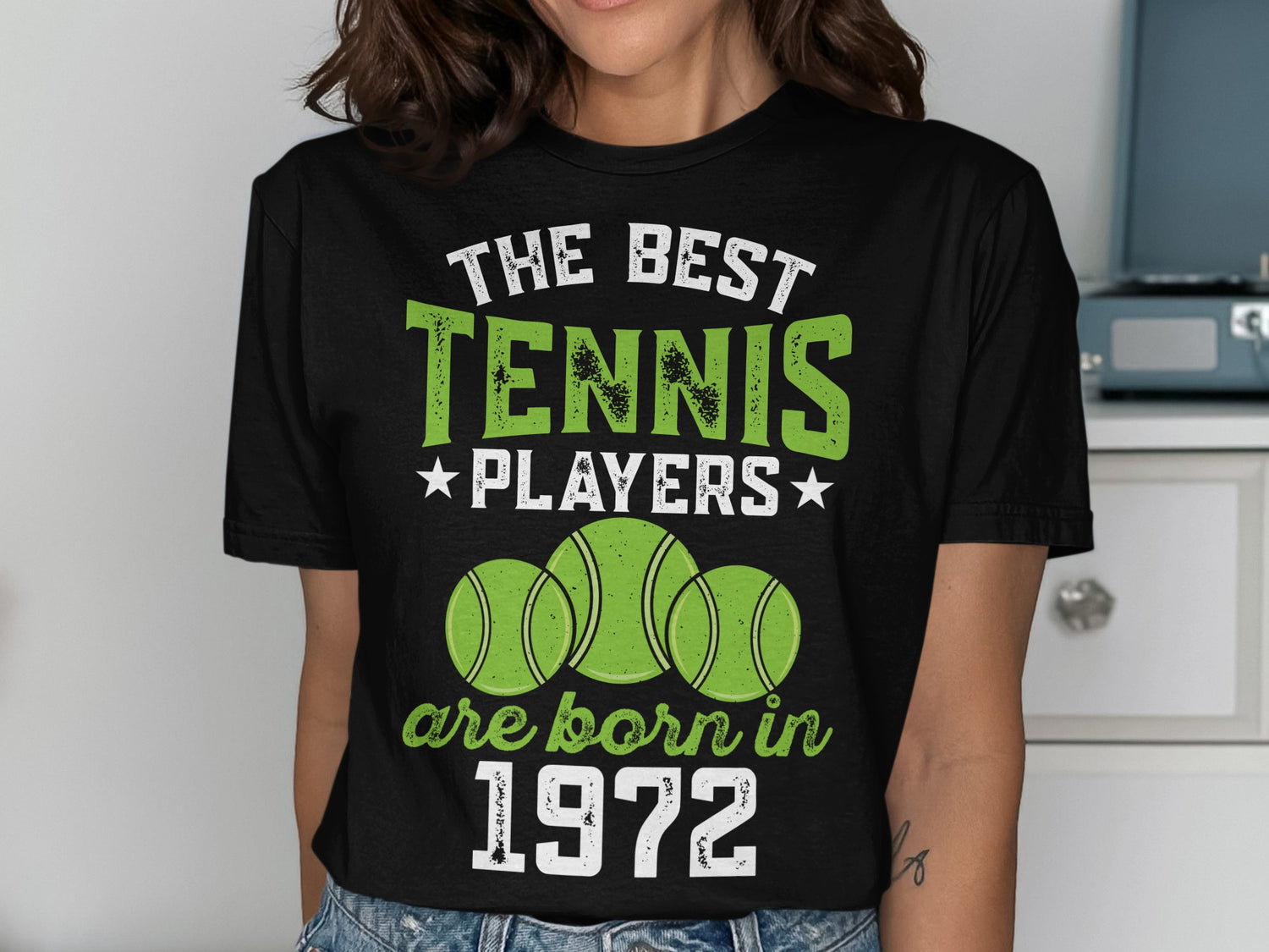 Black t-shirt with "The Best Tennis Players are Born in 1972" text and tennis balls.
