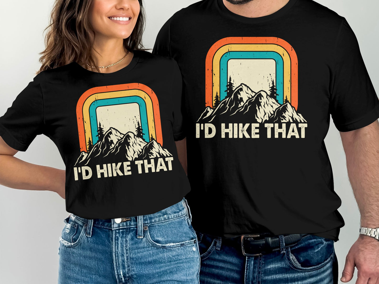 Two people wearing matching t-shirts with "I'd Hike That" and mountain graphic.