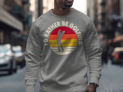 Gray sweatshirt with "I'd rather be golfing" text and sunset golfer graphic.