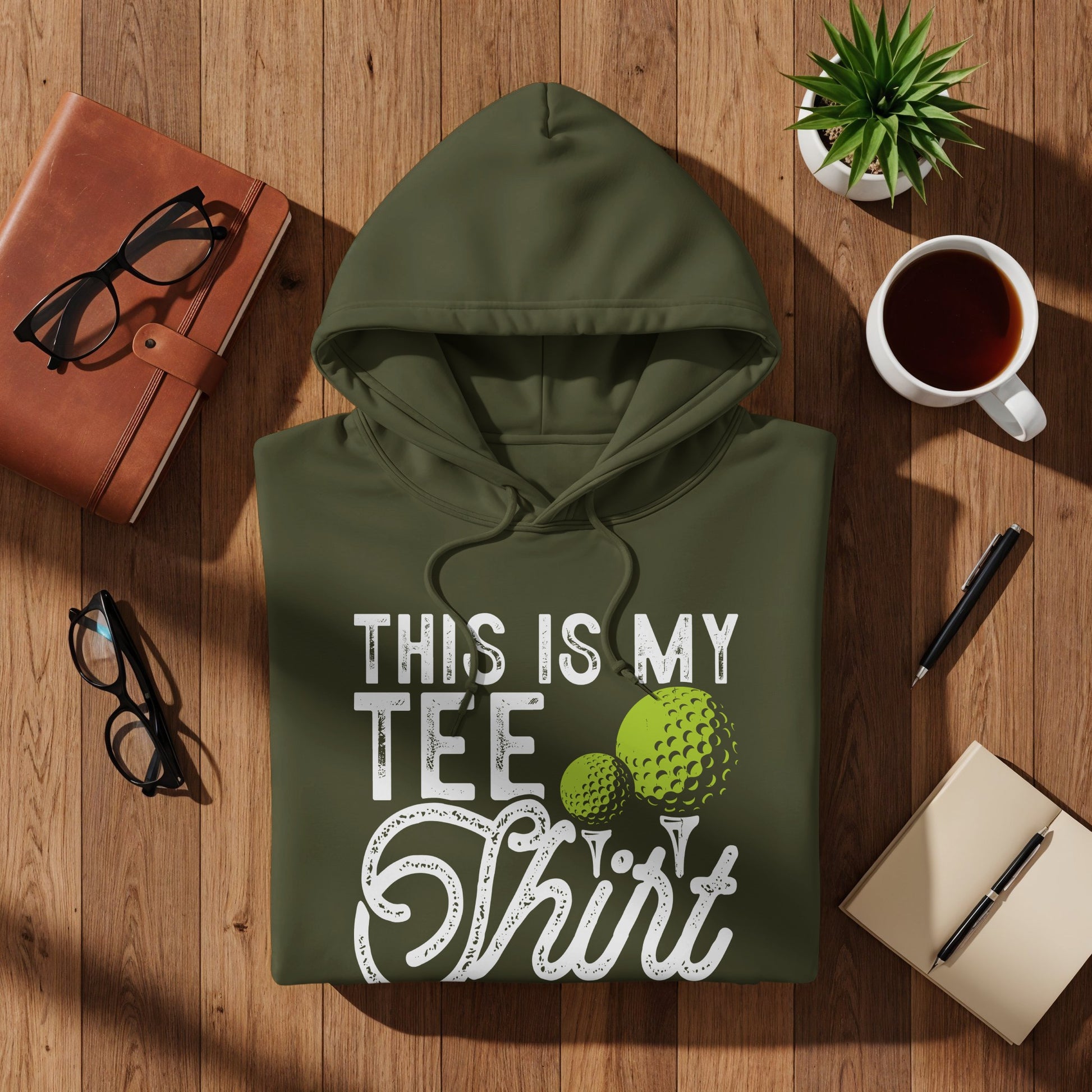 Green hoodie with "This is my Tee Shirt" text and golf balls.