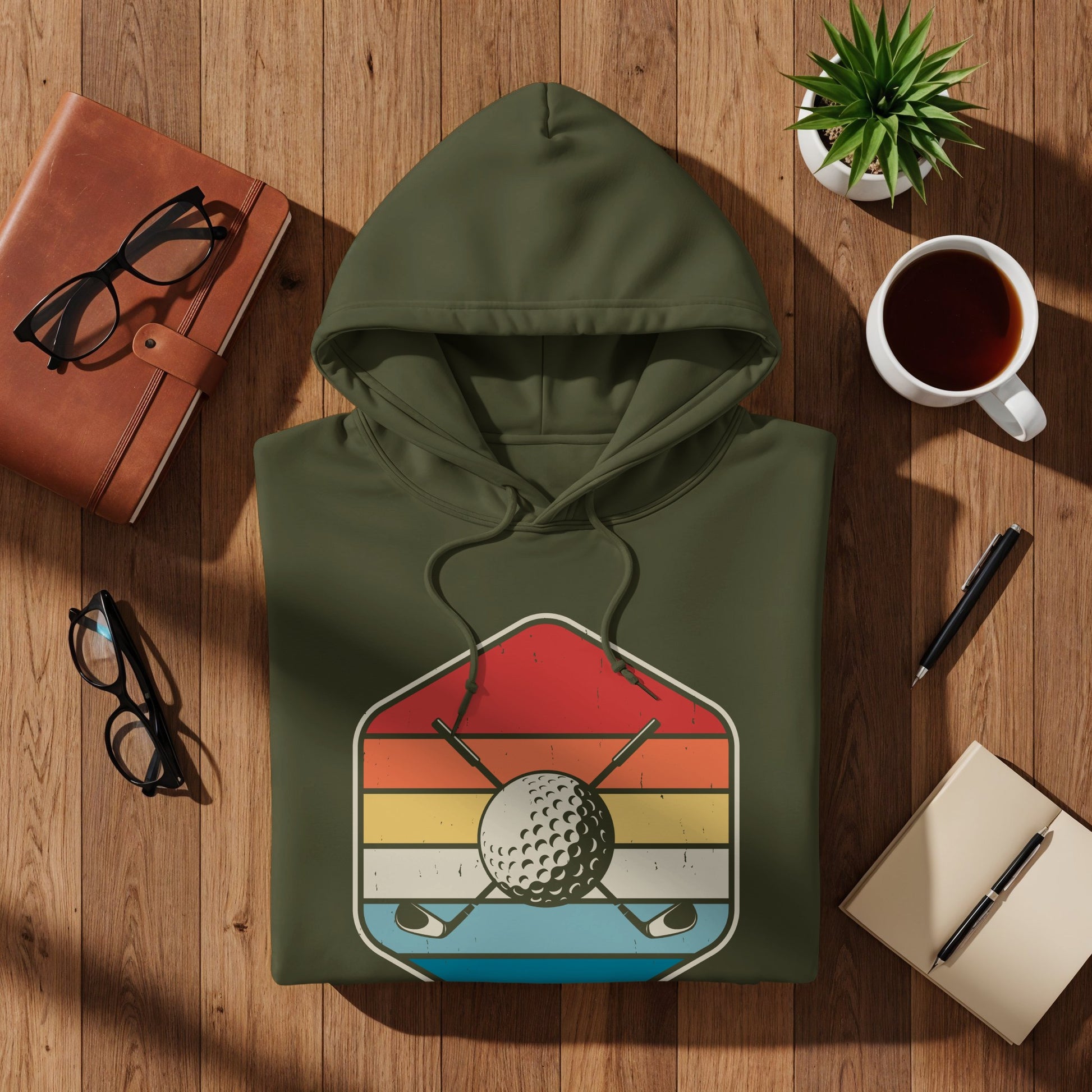 Green hoodie with retro golf graphic featuring crossed clubs and balls.