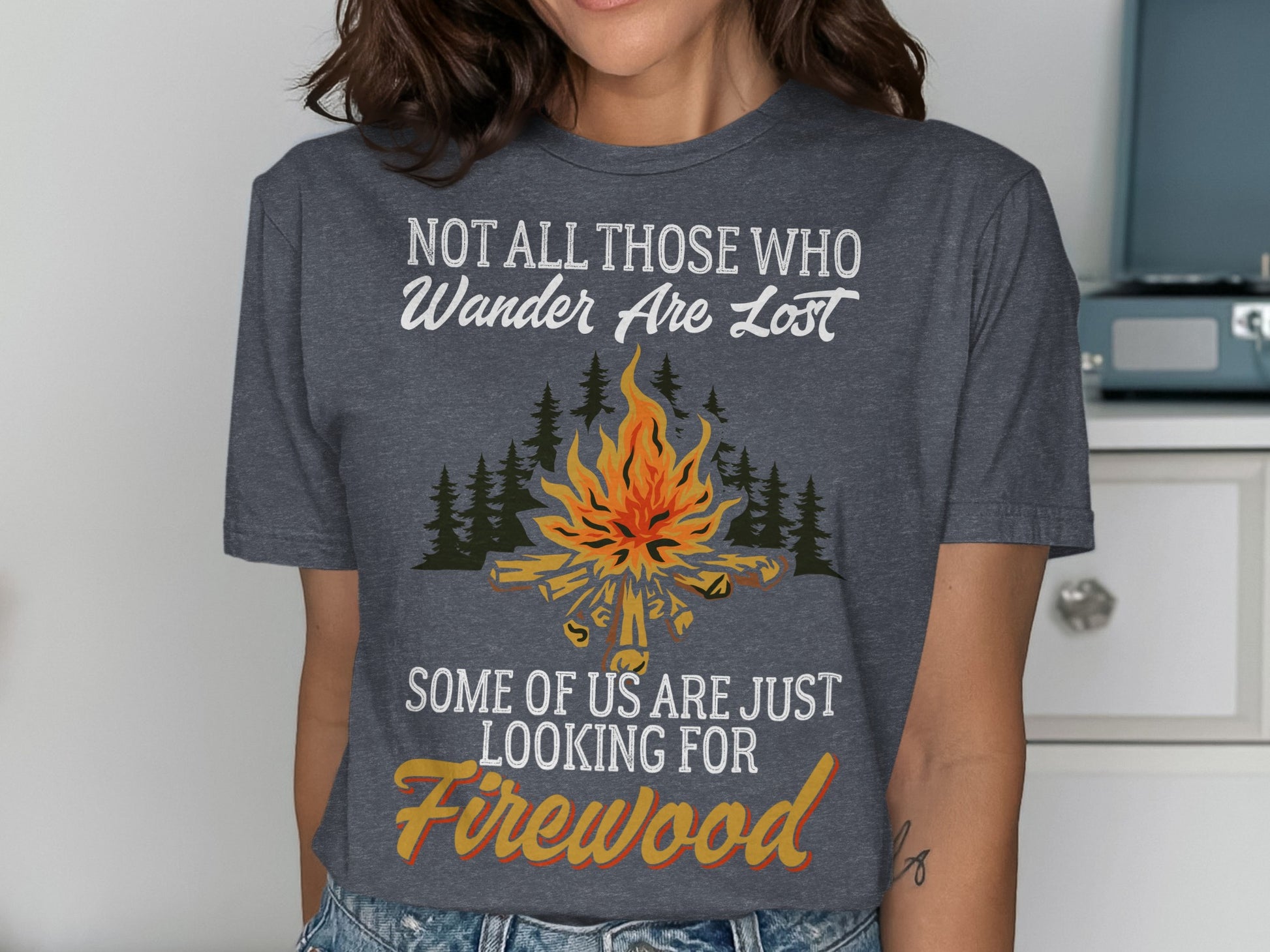 T-shirt with campfire, trees, and text "Not all those who wander are lost, some of us are just looking for Firewood".