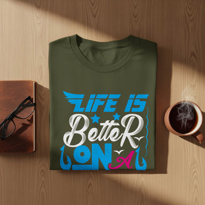 Olive green t-shirt with "Life is Better on" graphic, spectacles, and coffee.