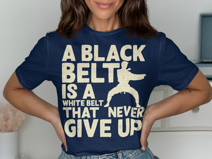 Navy t-shirt with white text and silhouette of martial artist: "A BLACK BELT IS A WHITE BELT THAT NEVER GIVE UP".