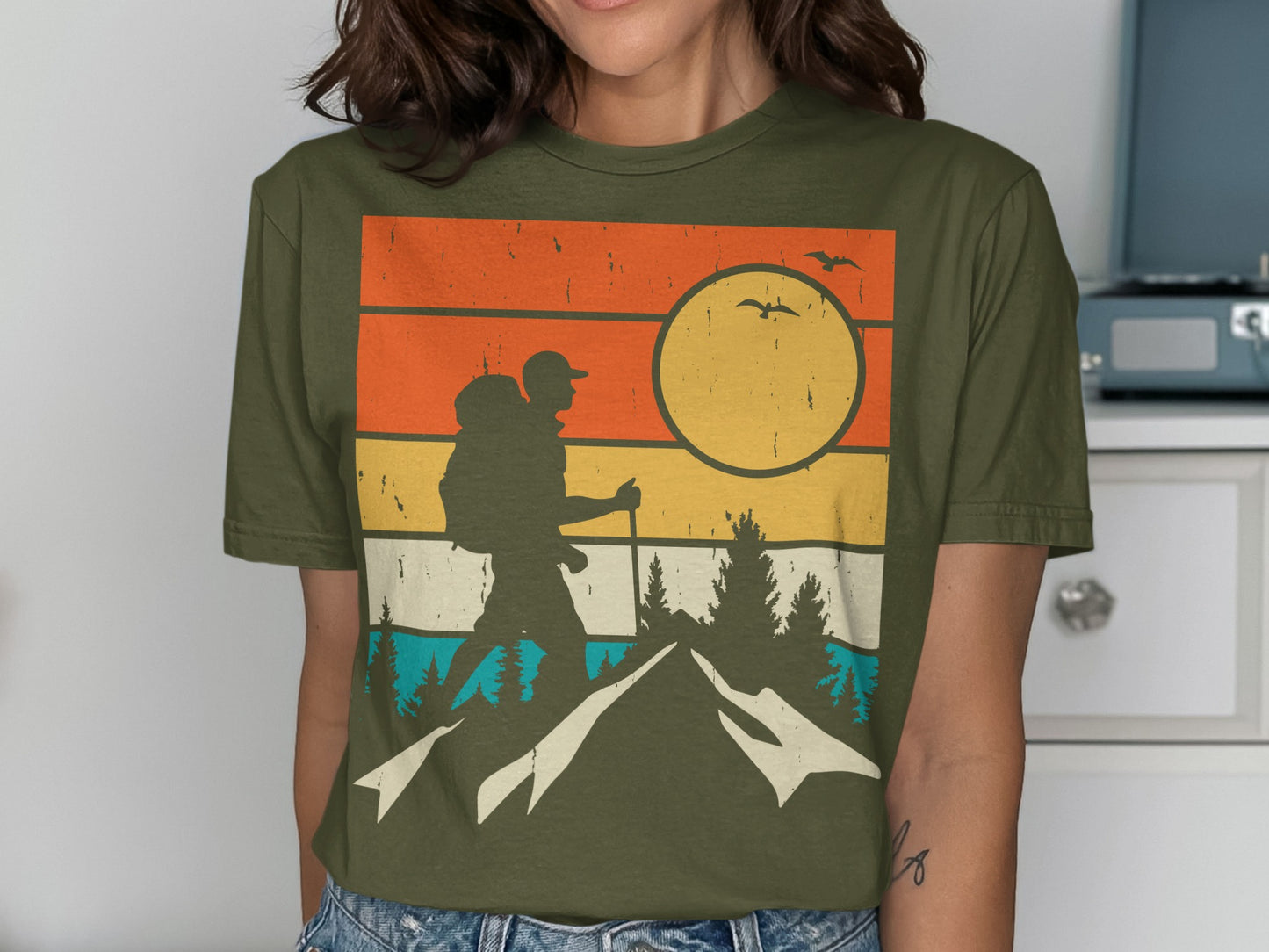 Retro sunset graphic tee featuring a hiker on a mountain.