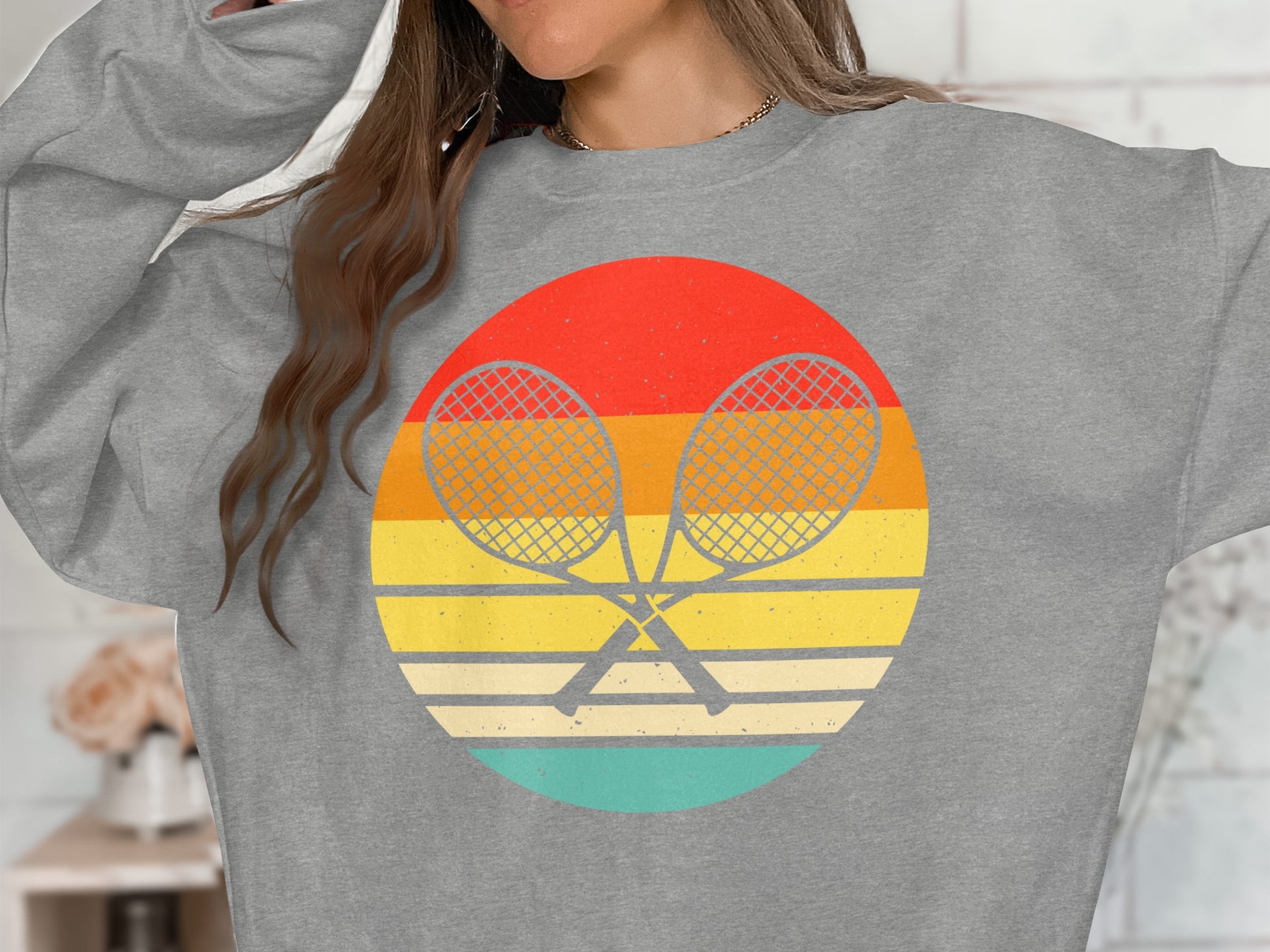 Gray sweatshirt with crossed tennis rackets on a retro striped circle graphic.