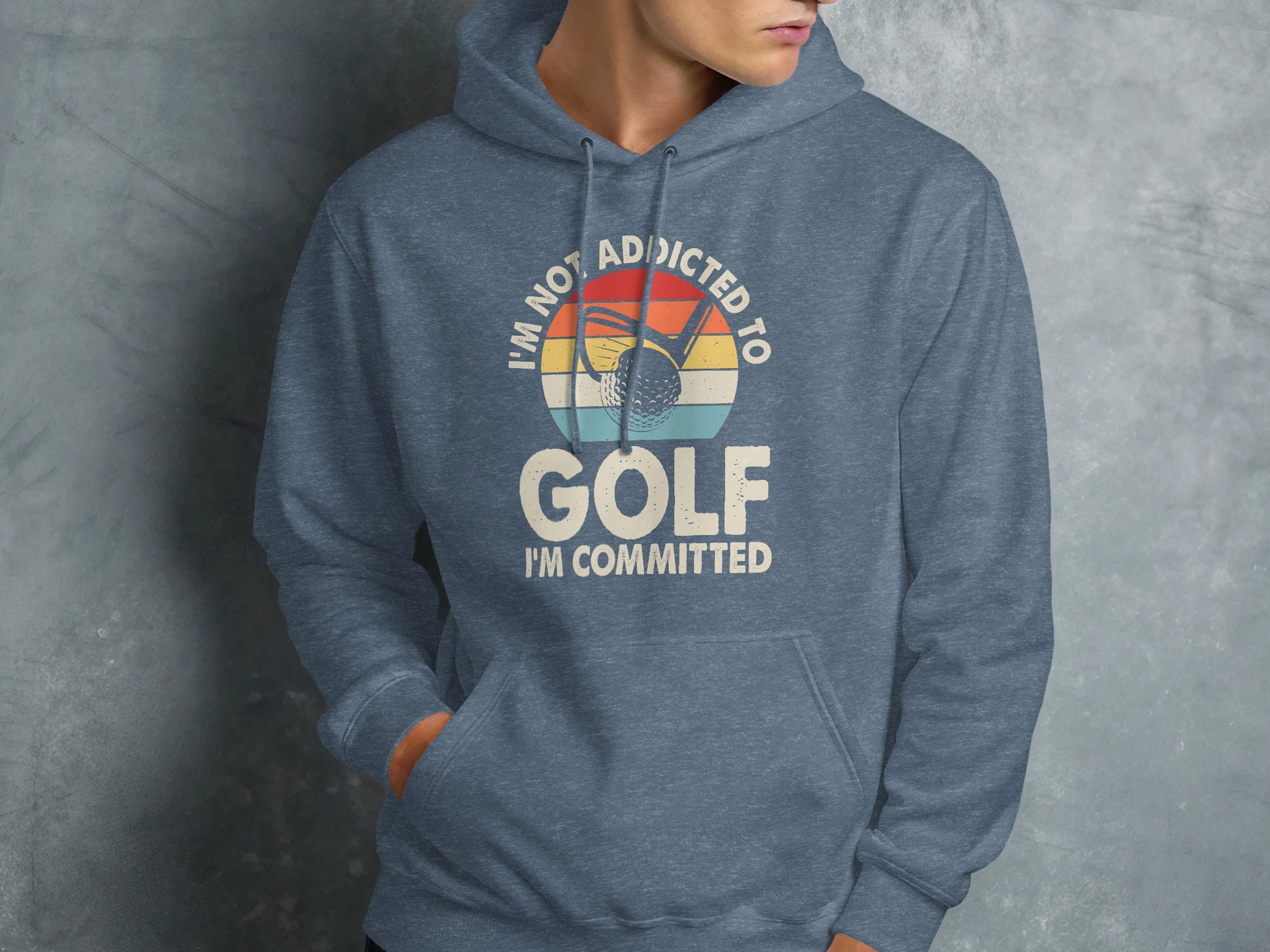 Blue hoodie with "I'm not addicted to golf, I'm committed" text and golf ball graphic.