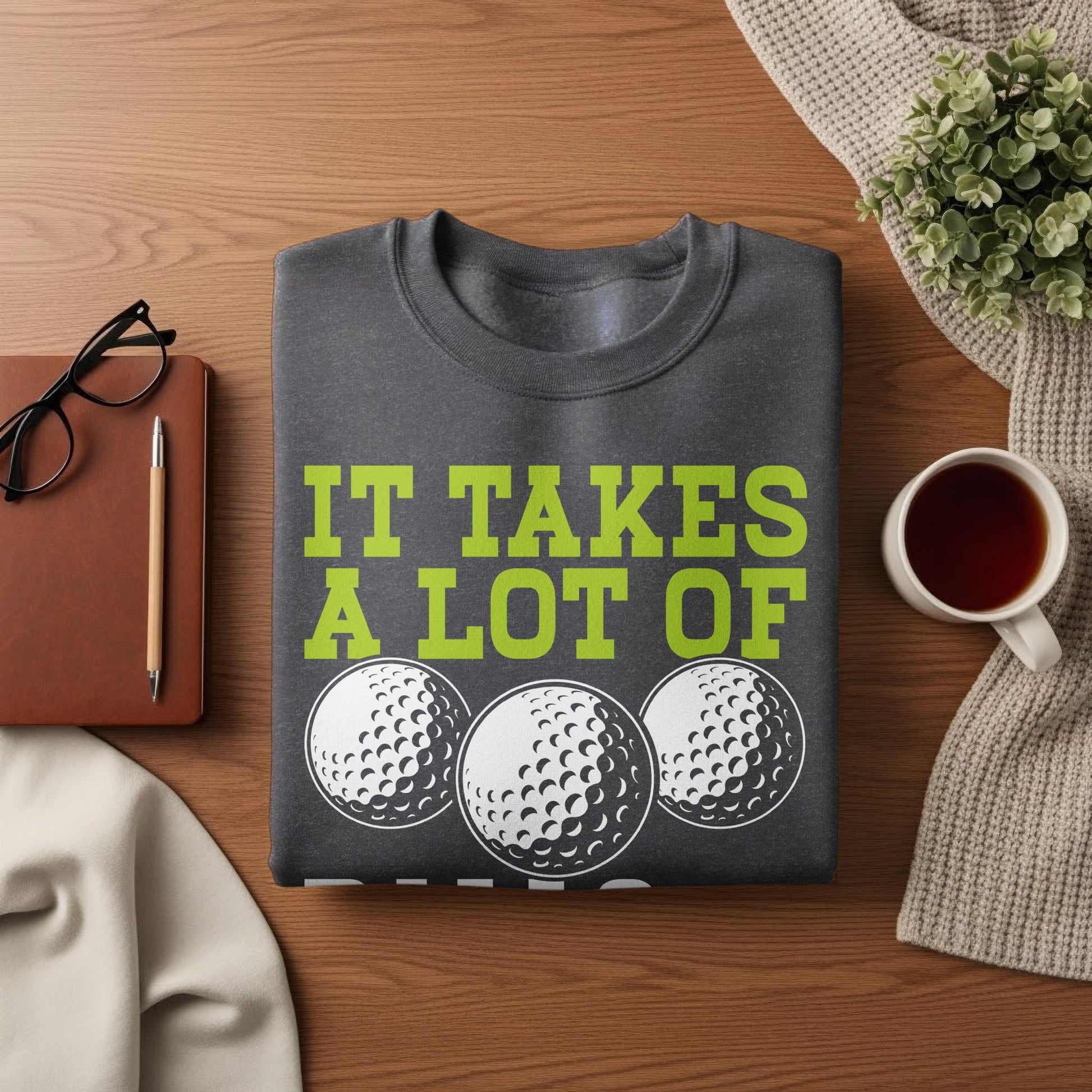 Dark grey sweatshirt with "IT TAKES A LOT OF" and three golf balls.
