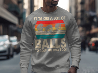 Gray sweatshirt with three golf balls and text "It takes a lot of balls to golf the way I do!".