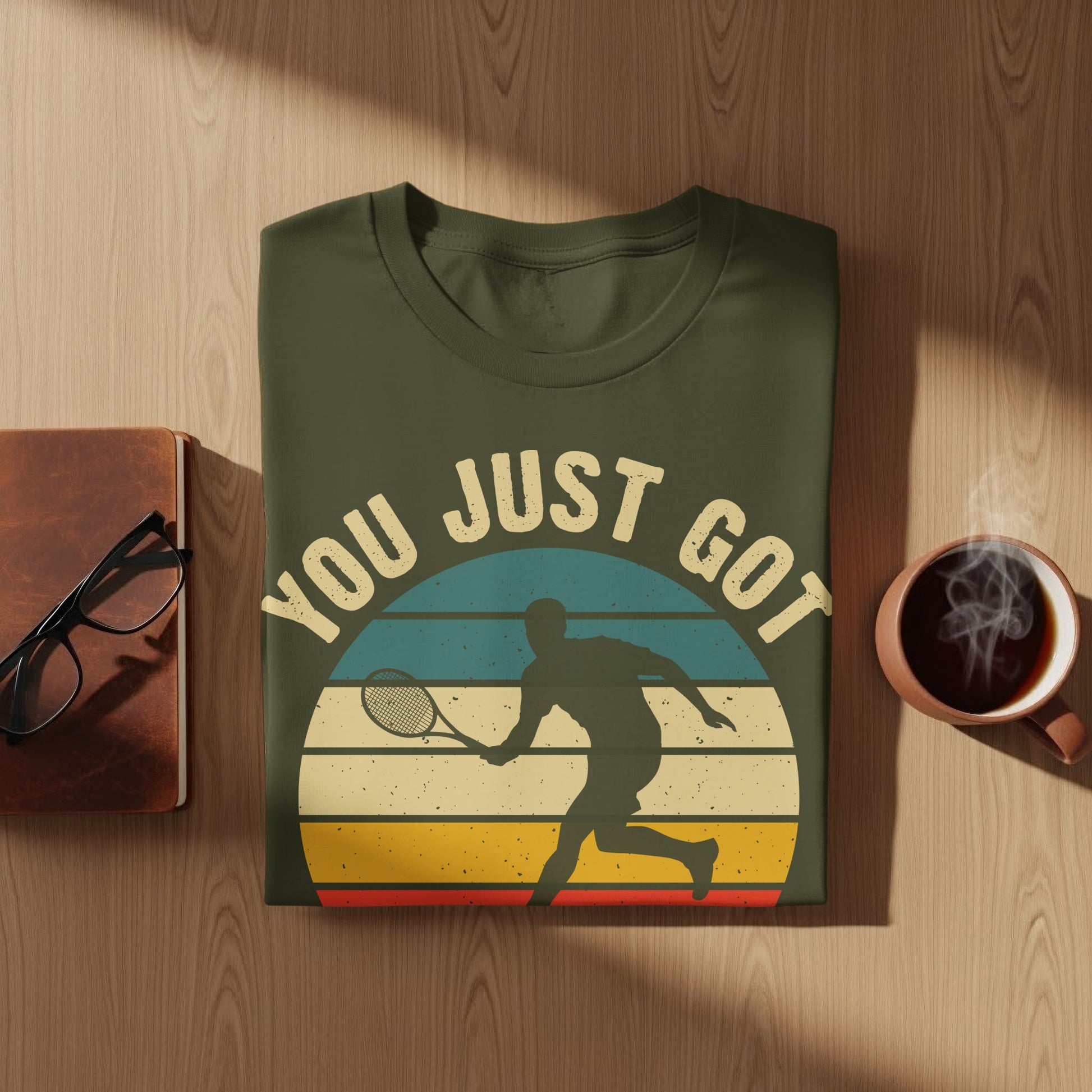 Green t-shirt with "YOU JUST GOT" text and tennis player silhouette graphic.