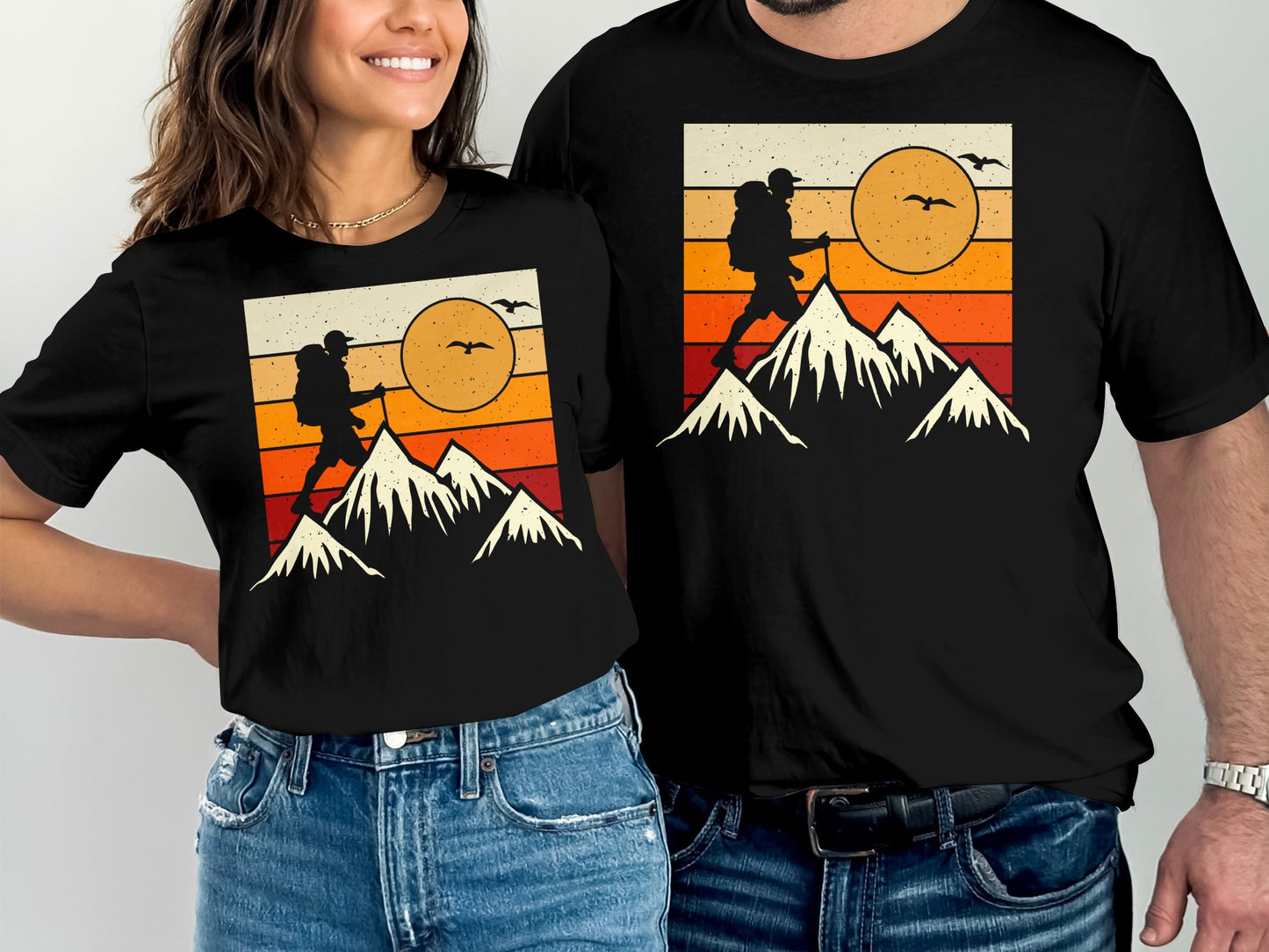 T-shirts with a vintage silhouette of a hiker on a mountain under a sunset.