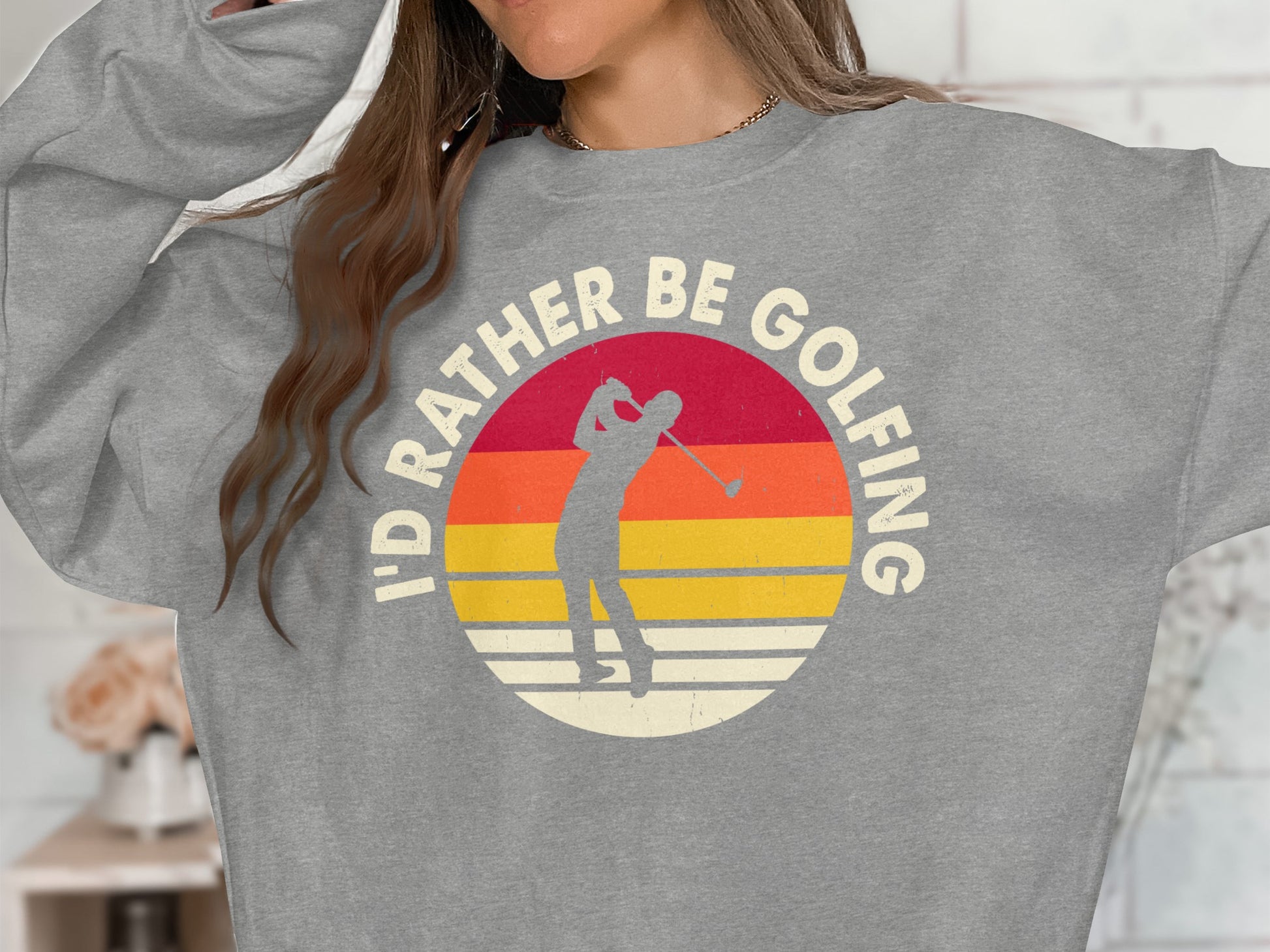 Grey sweatshirt with a retro sunset graphic and text "I'd rather be golfing."
