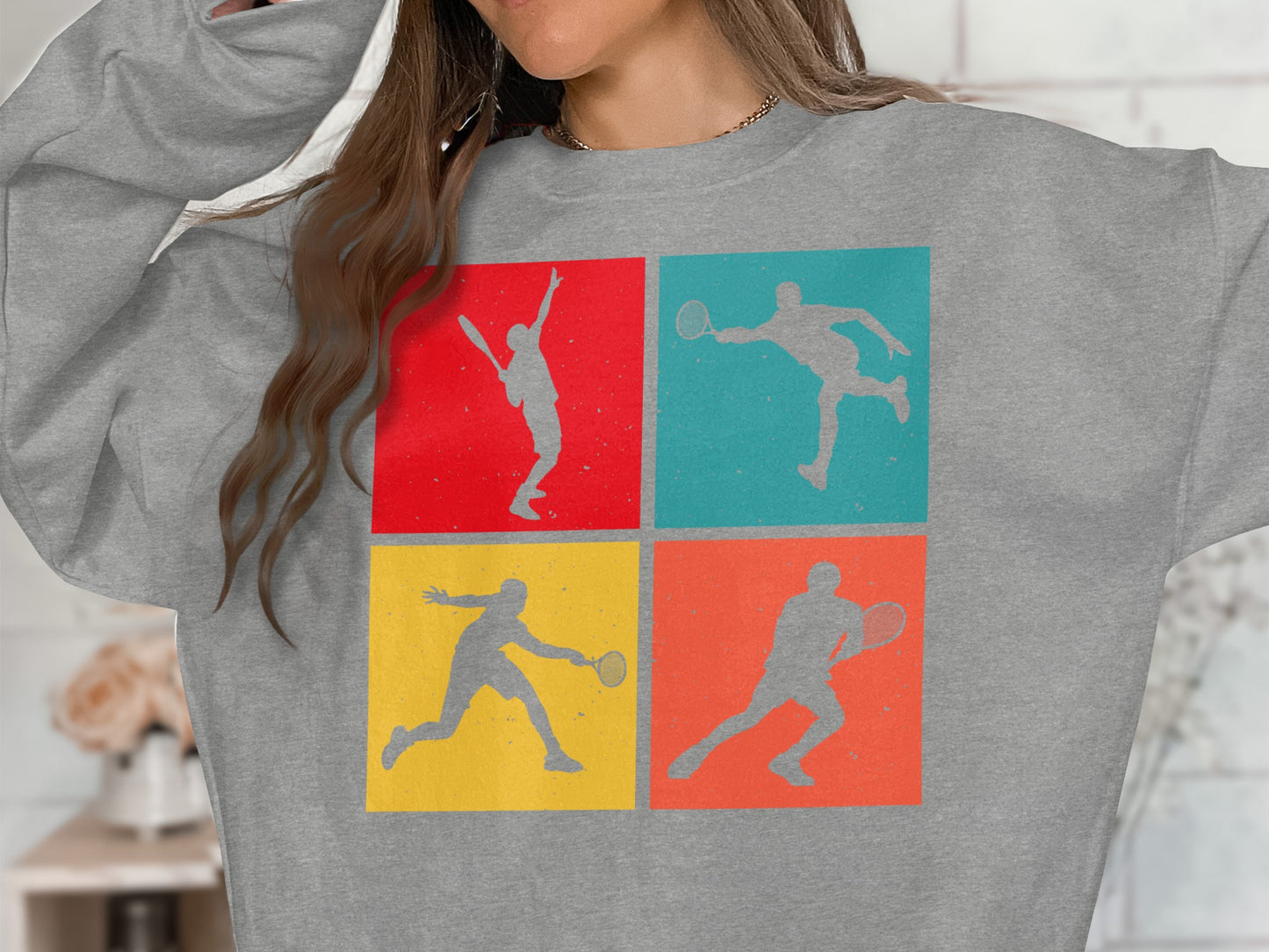 Gray sweatshirt with four colorful tennis player silhouettes in squares.