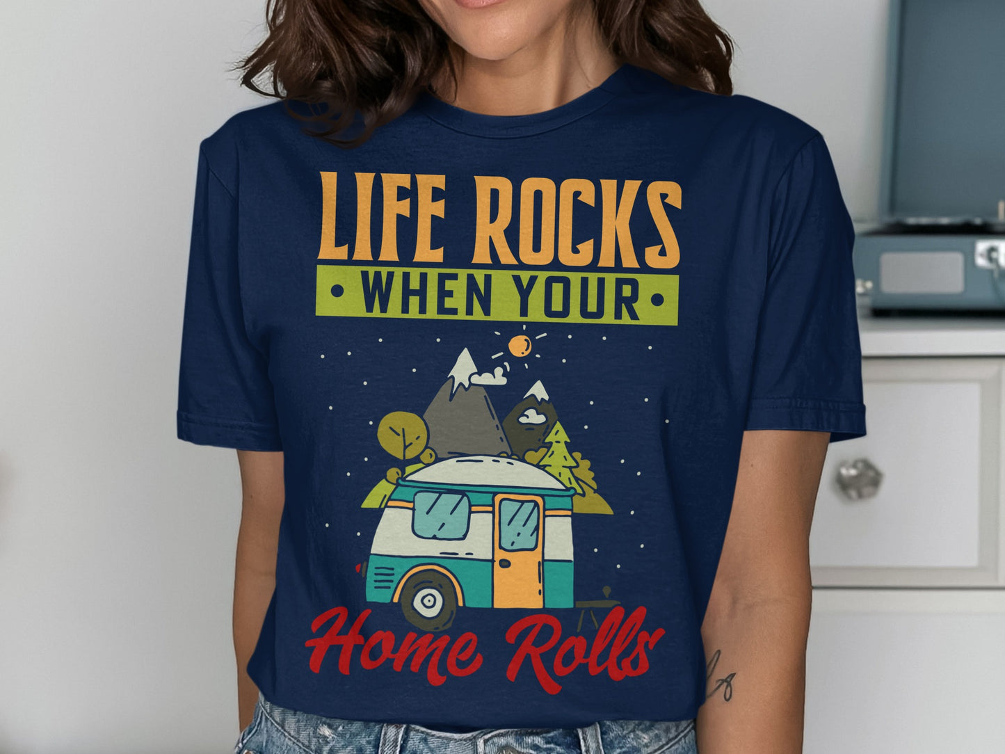 Dark blue t-shirt with "Life Rocks When Your Home Rolls" text and camper van illustration.