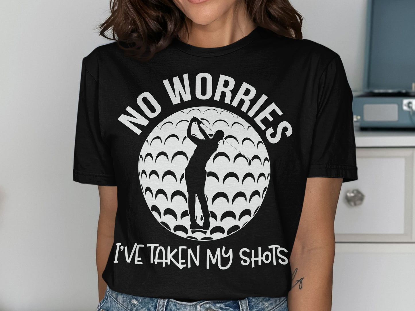 Black t-shirt with golfer silhouette, golf ball pattern, and text "NO WORRIES I'VE TAKEN MY SHOTS".