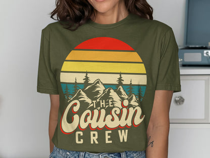 Olive green t-shirt with "The Cousin Crew" text and mountain sunset graphic.