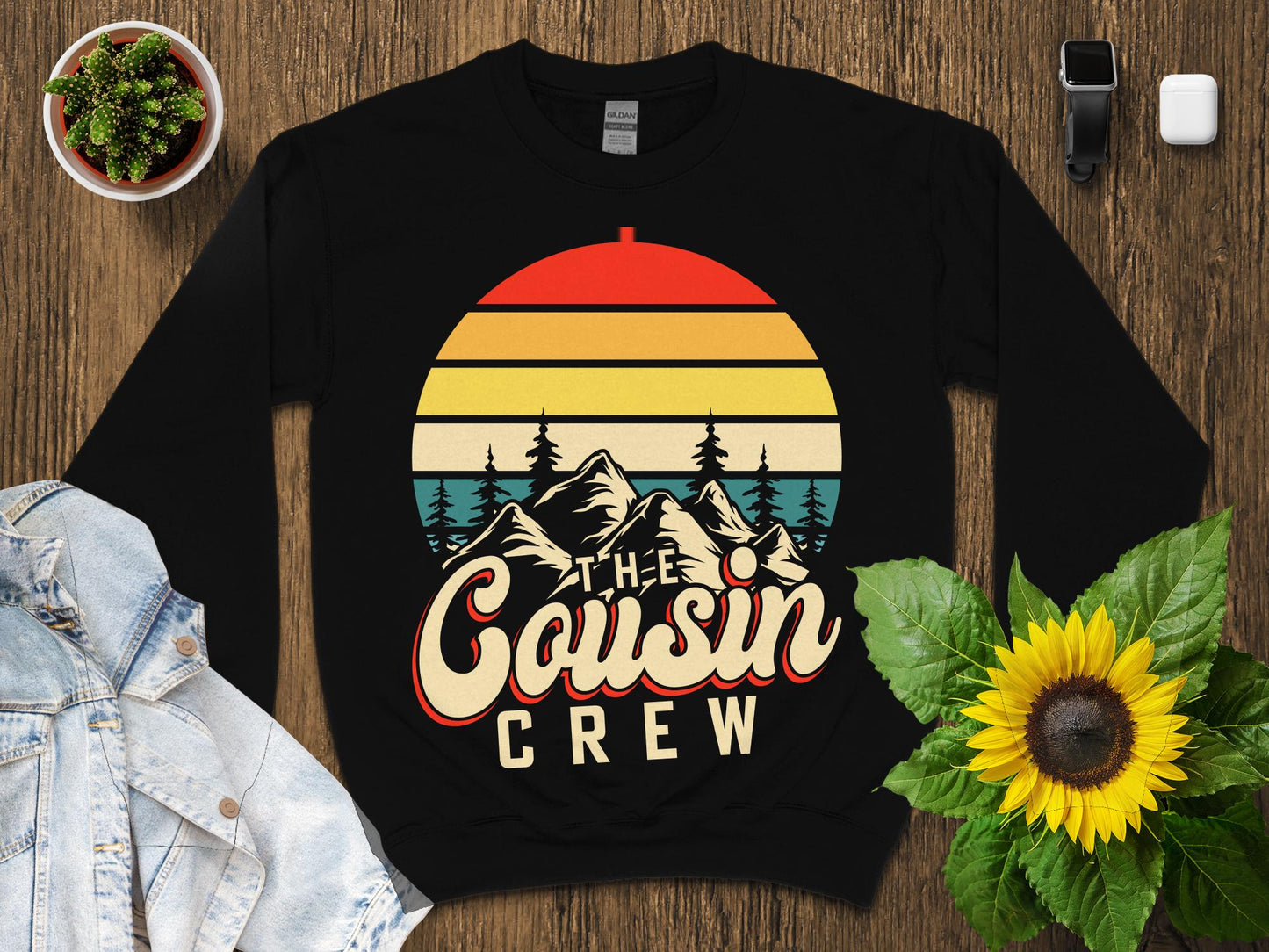Crewneck sweatshirt with "The Cousin Crew" text and mountain sunset graphic.