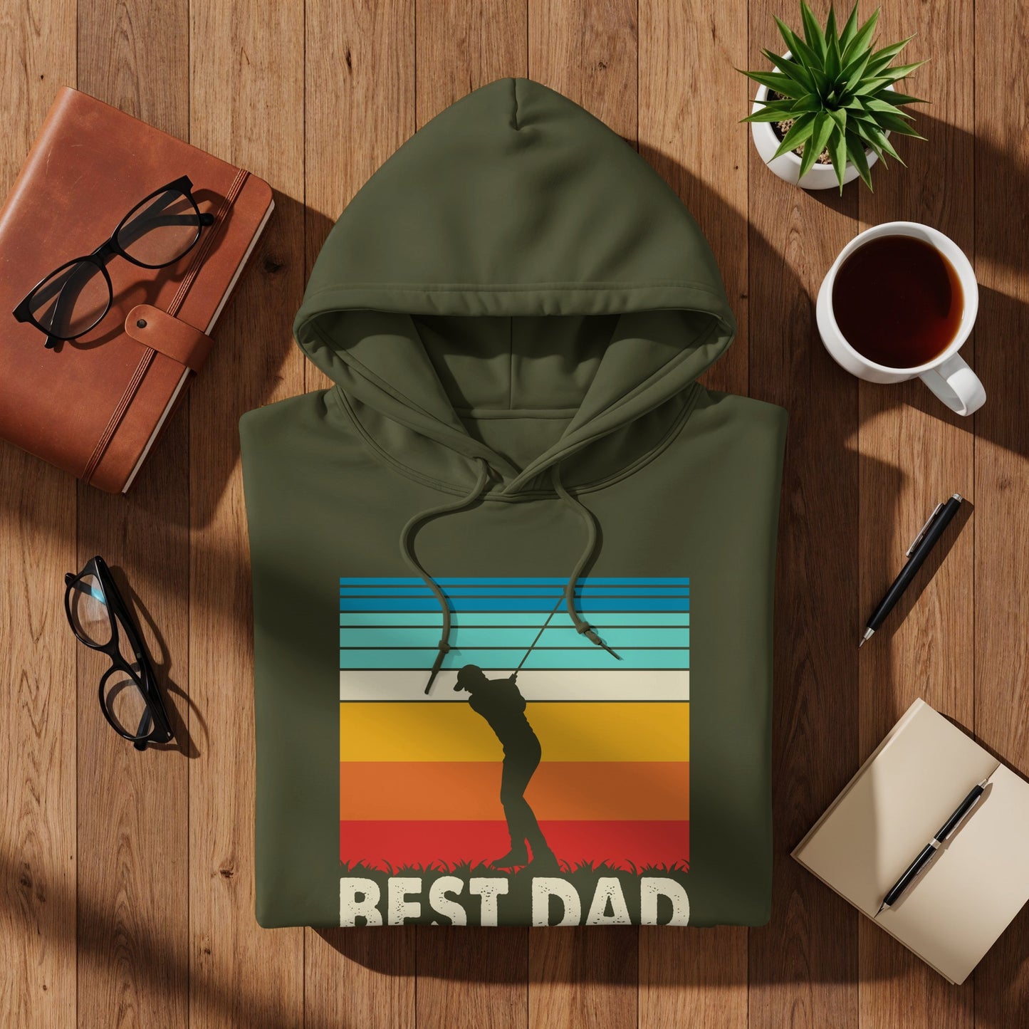 Olive green hoodie with "BEST DAD" text and a golfer sunset graphic.