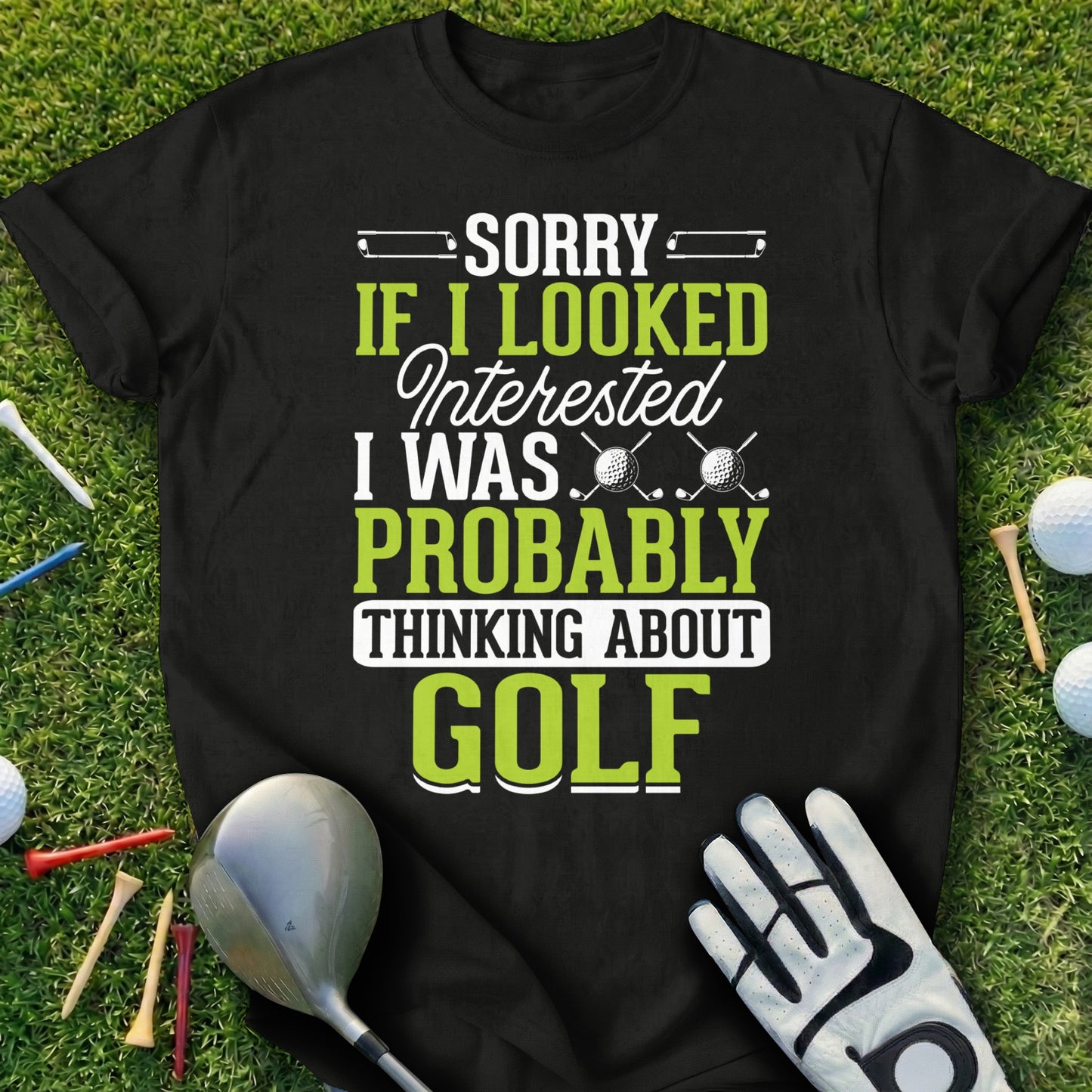 Black t-shirt with "Sorry if I looked I was probably thinking about Golf" and golf balls.