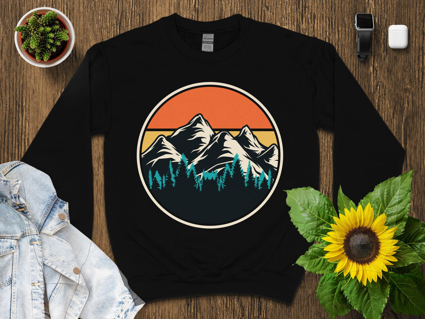 Black sweatshirt with a circular mountain and forest graphic.