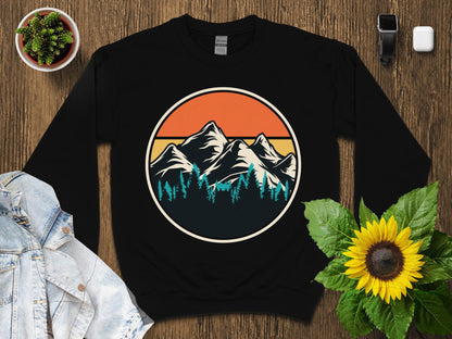 Black sweatshirt with a circular mountain and forest graphic.