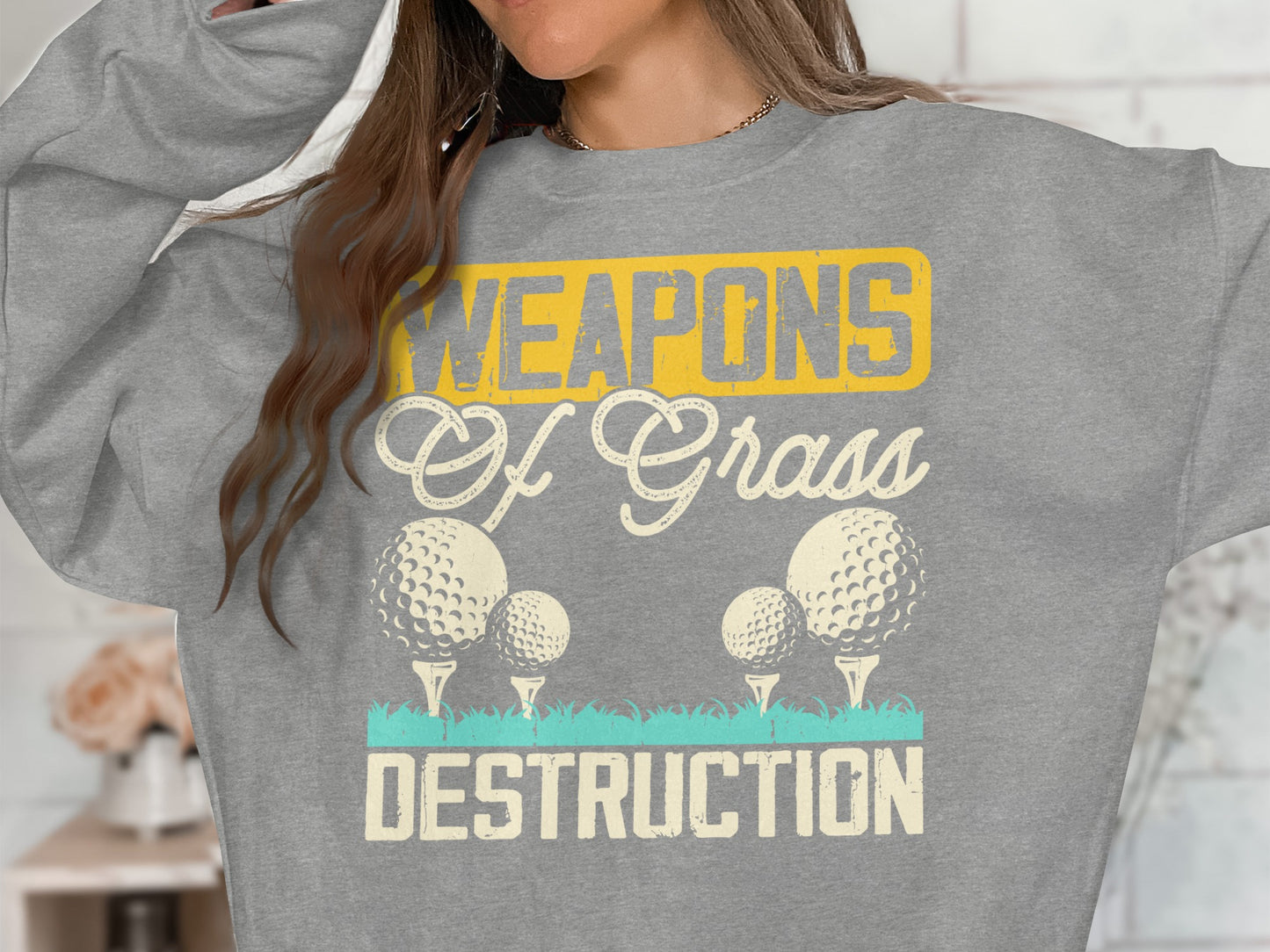 Grey sweatshirt with "WEAPONS Of Grass DESTRUCTION" and golf balls.