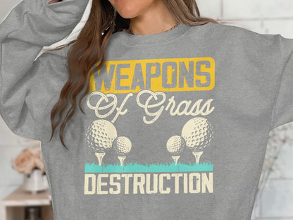 Grey sweatshirt with "WEAPONS Of Grass DESTRUCTION" and golf balls.