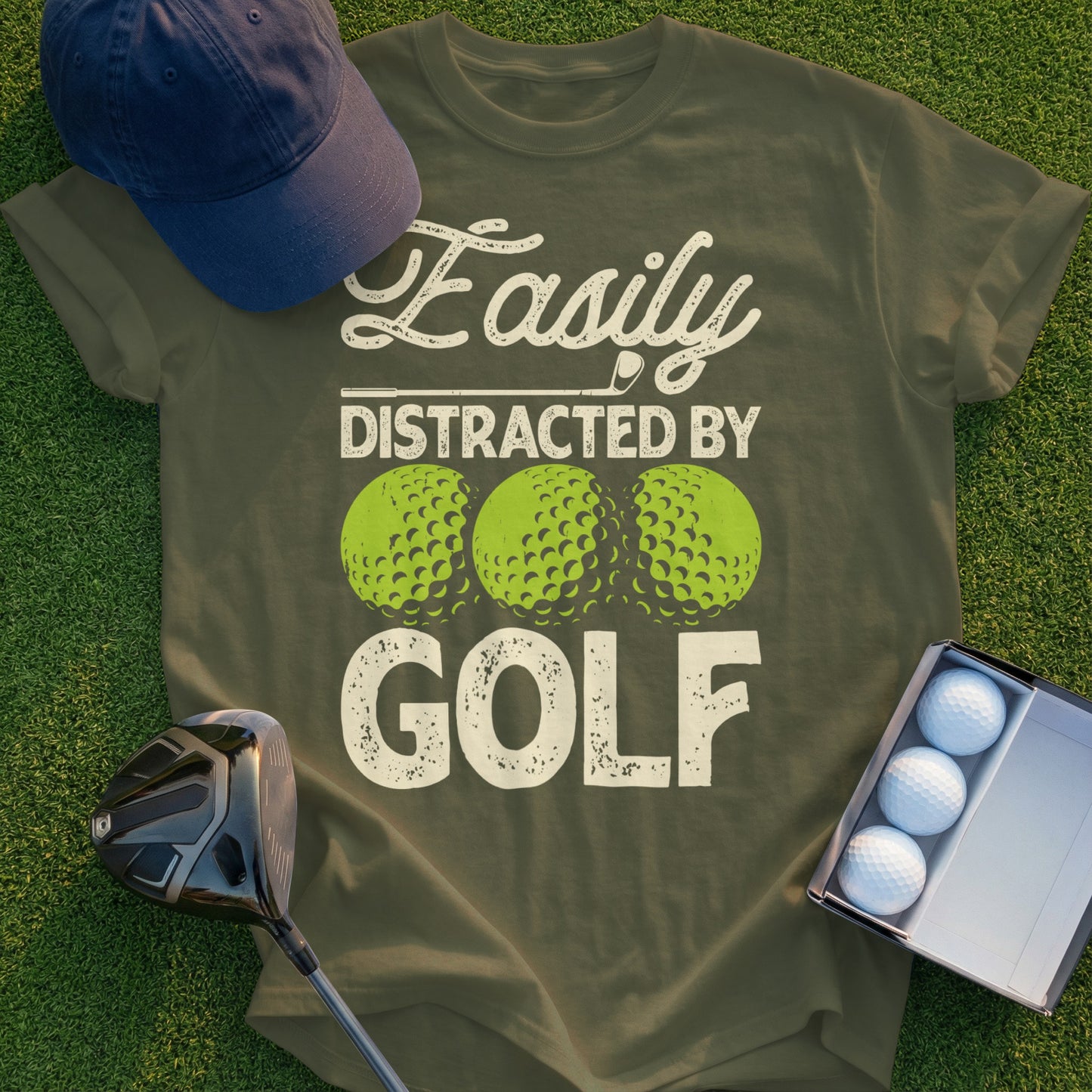 Olive green t-shirt with "Easily Distracted By GOLF" and three golf balls.