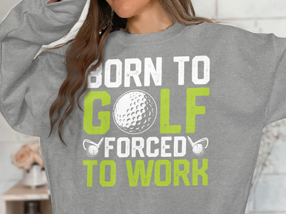 Grey sweatshirt with "BORN TO GOLF FORCED TO WORK" text and golf ball graphic.