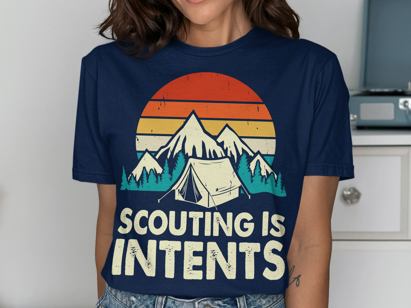 Navy t-shirt with retro mountain and tent graphic and "Scouting is Intents" text.