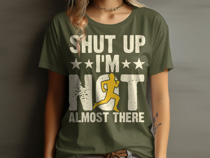 Green t-shirt with white text "Shut up, I'm almost there" and runner graphic.