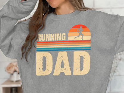 Grey sweatshirt with "RUNNING DAD" text and sunset graphic.