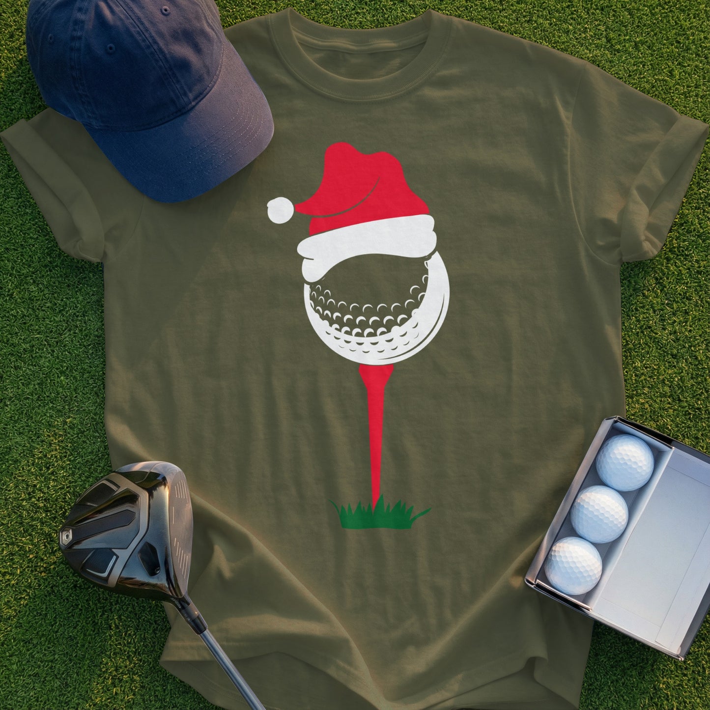 Golf ball with Santa hat on tee, green grass background, golf club and balls.