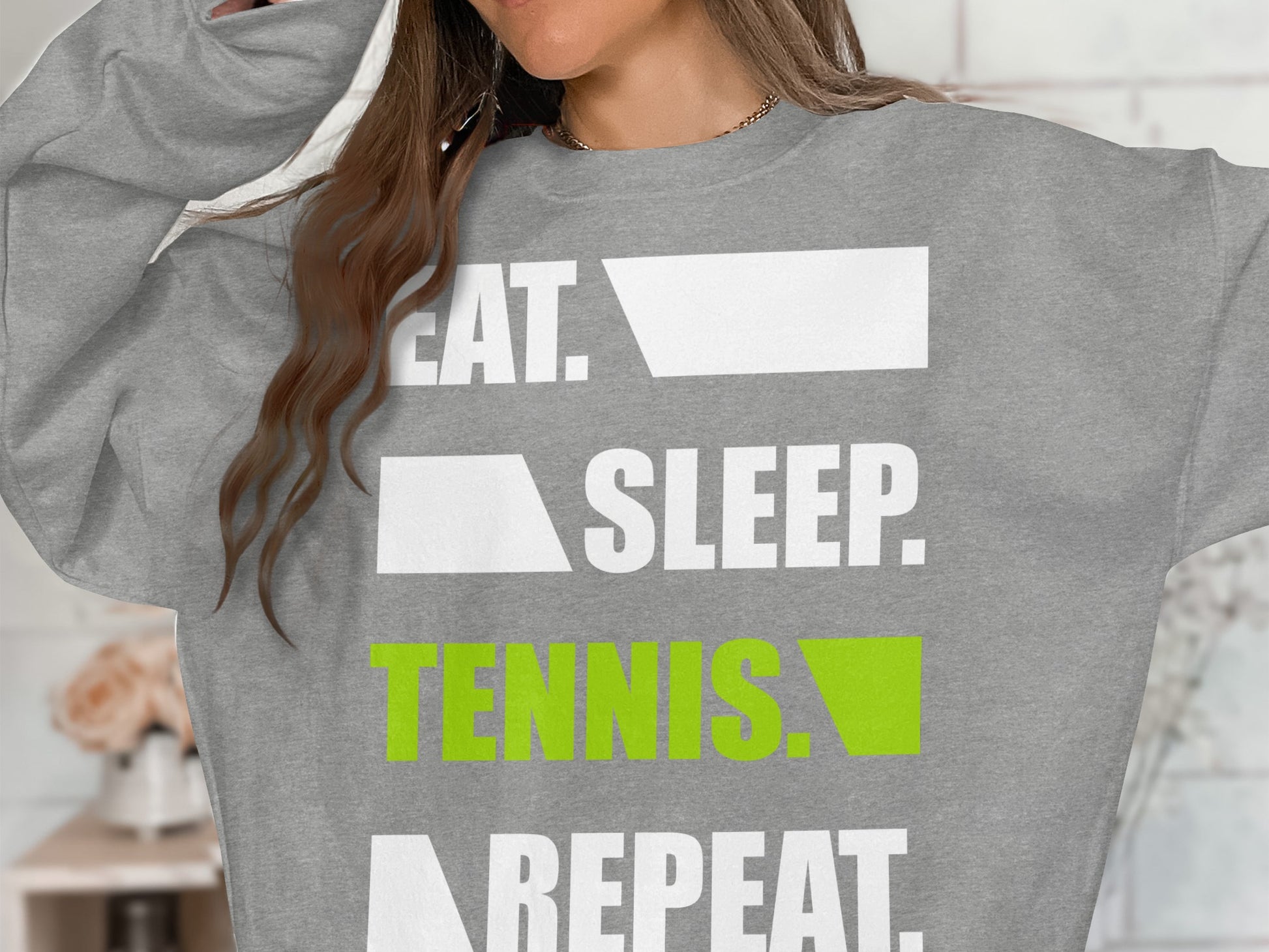 Grey sweatshirt with "EAT. SLEEP. TENNIS. REPEAT." text in white and green.